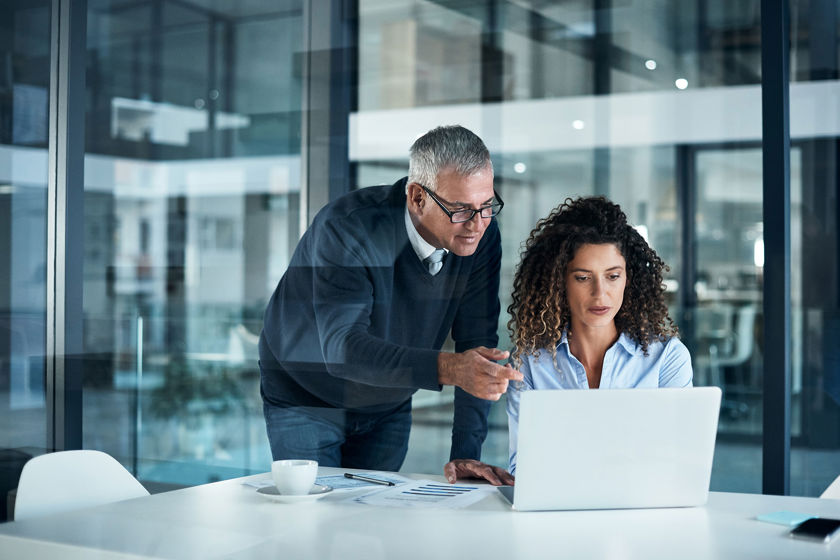 Two Colleagues Reviewing Laptop In Office 