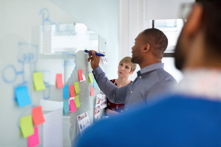 Colleagues Brainstorming At A Whiteboard 
