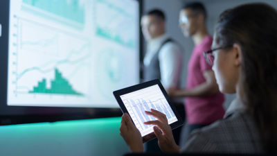 Colleagues Viewing Solutions On Multiple Displays 