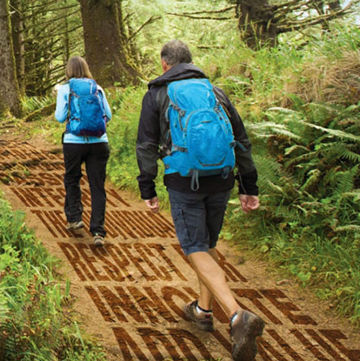 Photo illustration of two hikers on forest trail superimposed with words describing the Verisk Way