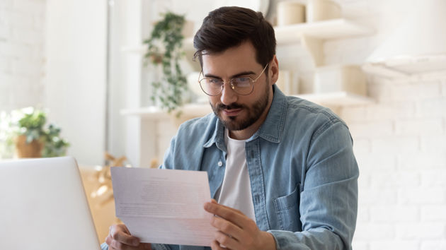 Person Reviewing Document At Desk 