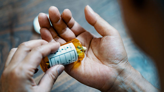 Hand Holding Pill Bottle 