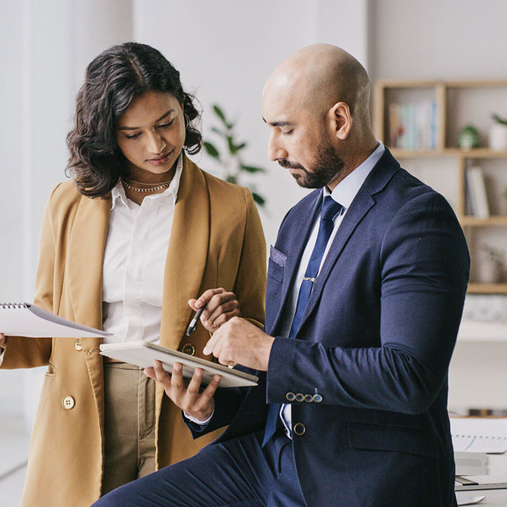 Coworkers Reviewing Data On Tablet Computer 