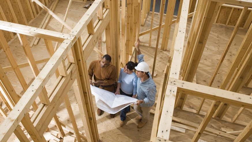 builder-and-homeowner-reviewing-blueprints-in-framed-home (1)