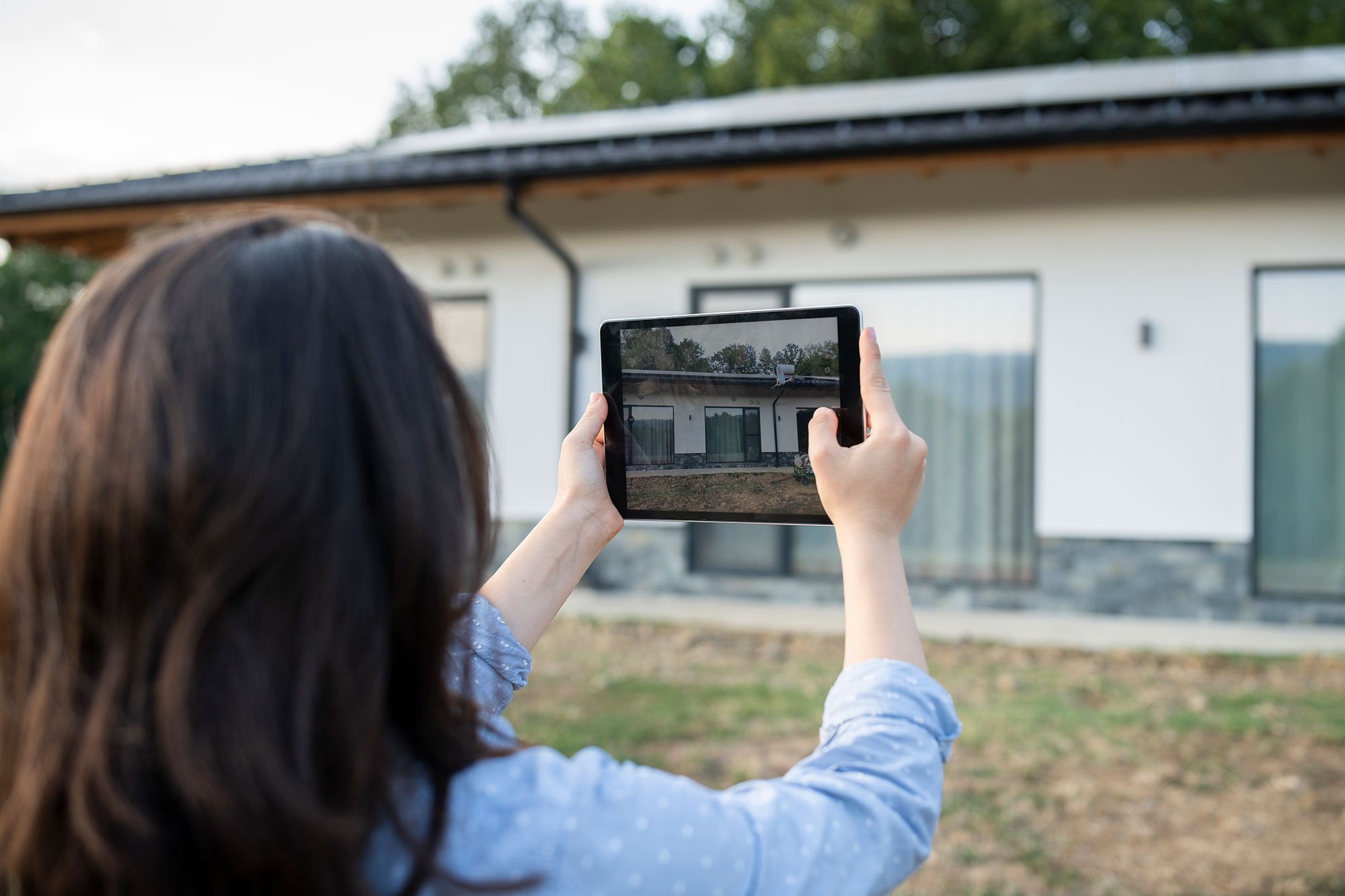 Viewing Photo Of Home Exterior On Tablet 