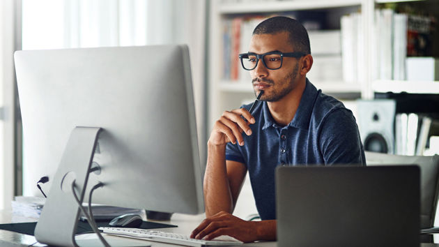 Person Concentrating On Desktop Screen 
