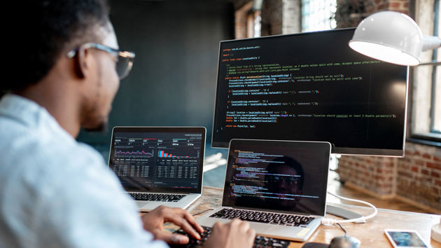 Person Viewing Code On Three Screens 