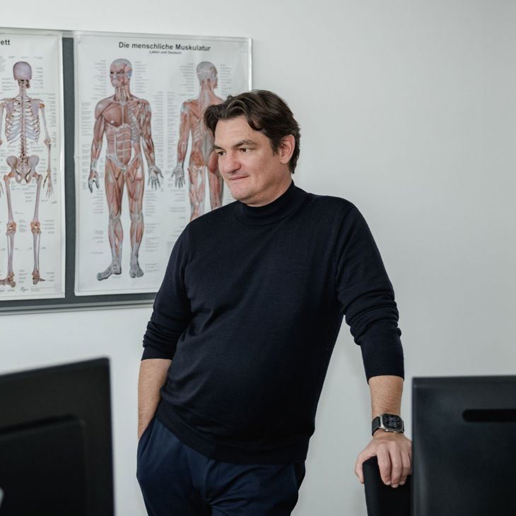Man Standing In Front Of Medical Wall Charts 