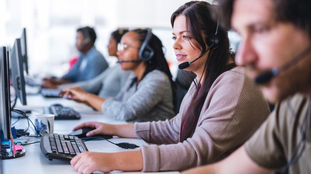 Row Of Customer Service Workers With Headsets 