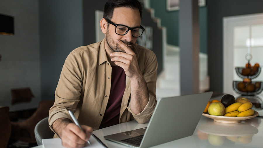 man-in-kitchen-reviewing-data-on-laptop