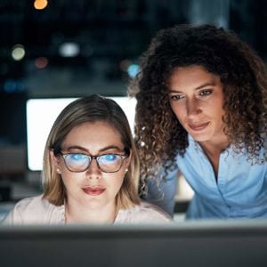 Two Colleagues Looking Intently At Data On Screen 