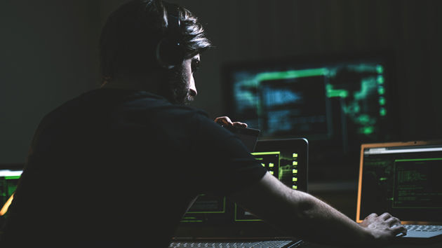 Hacker With Credit Card In Dark Room 