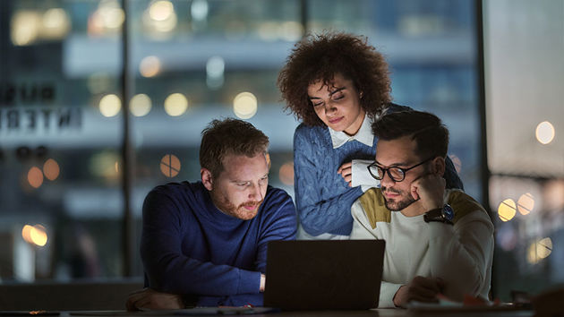 Coworkers Sharing Laptop Screen 